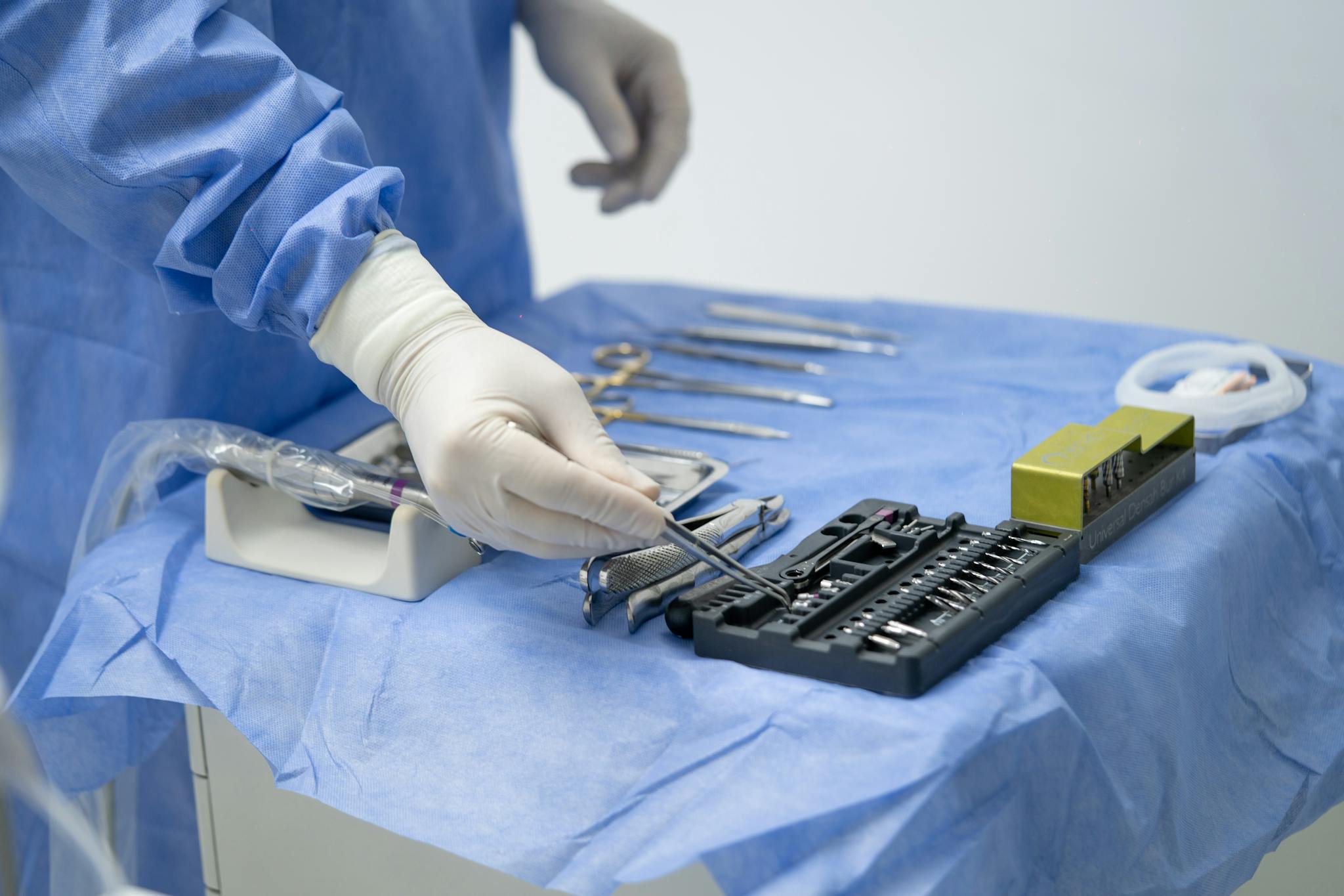 Close-up of a surgeon arranging tools in an operating room, showcasing precision and readiness.