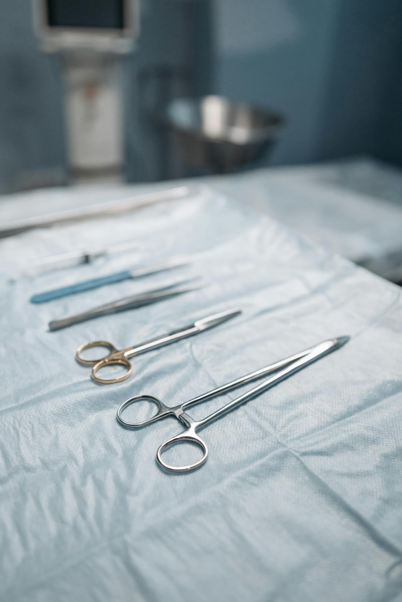 Close-up of surgical tools on a sterile drape in an operating room.